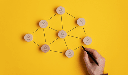 Conceptual image of network marketing - male hand connecting the wooden cut circles with person icon on them.